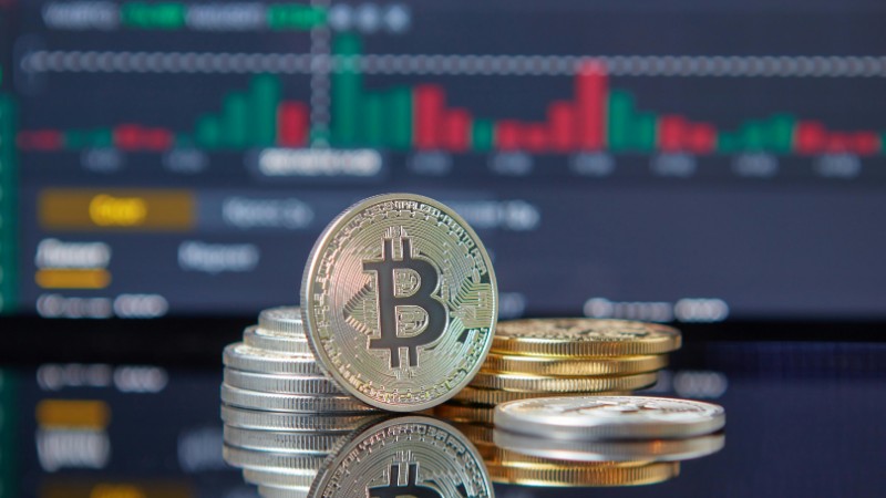Close-up of Bitcoin coins on reflective surface with financial trading chart, symbolizing cryptocurrency market dynamics., tags: trends small-business - pexel