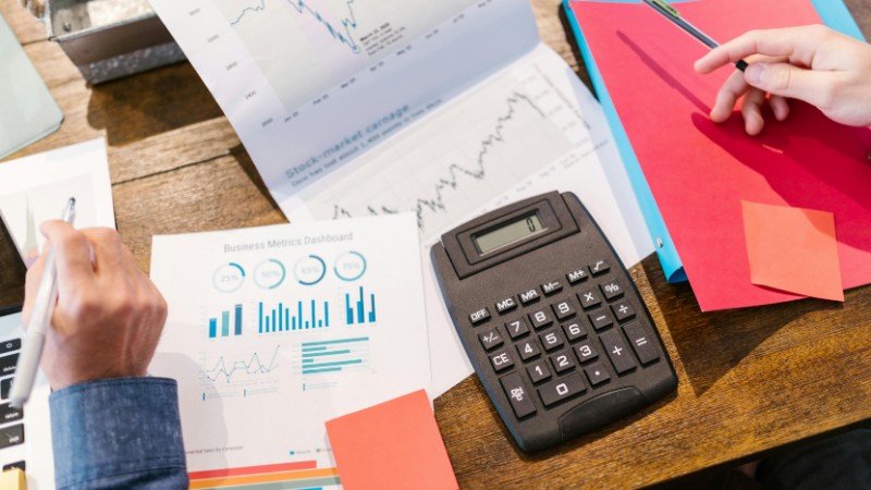 Financial analysis and planning tools with graphs and calculator on a table., tags: growth - pexel