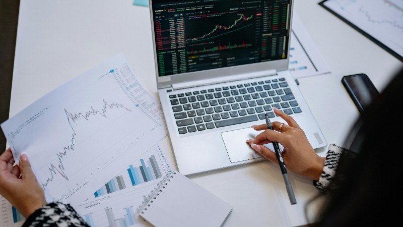 A detailed look at business analysis with a laptop displaying graphs and financial charts on a table., tags: global equity markets - pexel