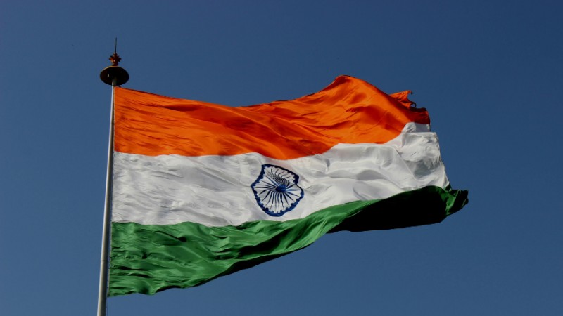 The Indian national flag waves proudly against a clear blue sky, symbolizing unity and pride., tags: india global economic - pexel