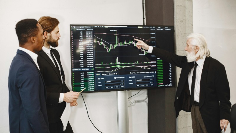 A diverse business team in a meeting analyzing stock market data on a screen., tags: 2026 - pexel