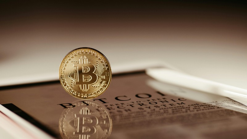 A floating Bitcoin reflecting on a glossy surface symbolizing cryptocurrency trading., tags: regulatory wall street - pexel