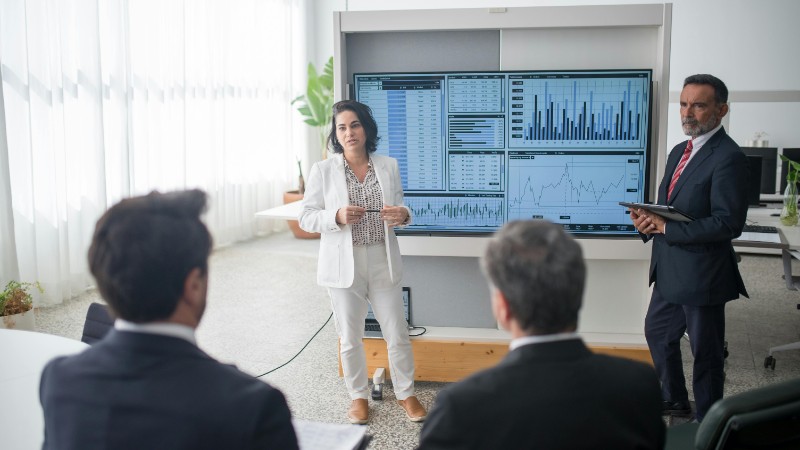 Colleagues discussing financial charts during a corporate meeting in a modern office., tags: global economy cautious growth slows priorities - pexel