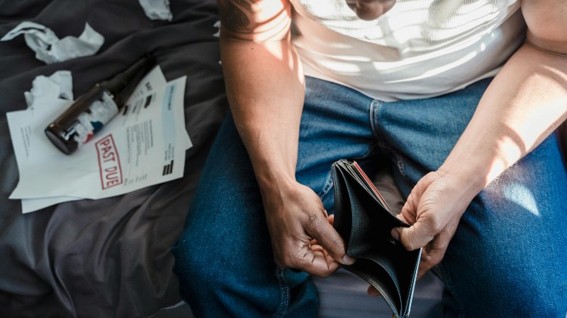 Depicts financial stress with overdue bills and empty wallet., tags: euro area - pexel