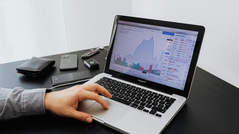 Person analyzing stock market data on a laptop at a desk., tags: uk shares - pexel